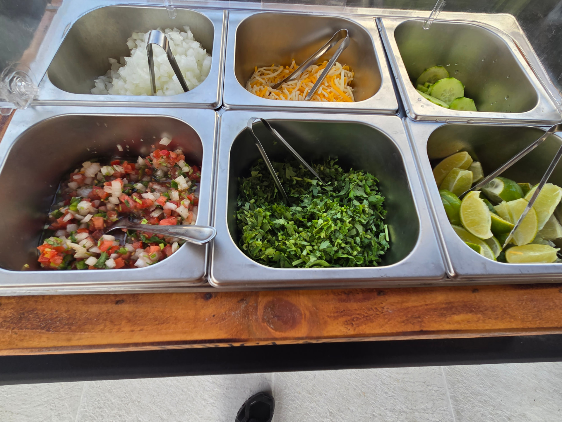 Close-up of onions, cheese, cucumber, pico, cilantro and limes